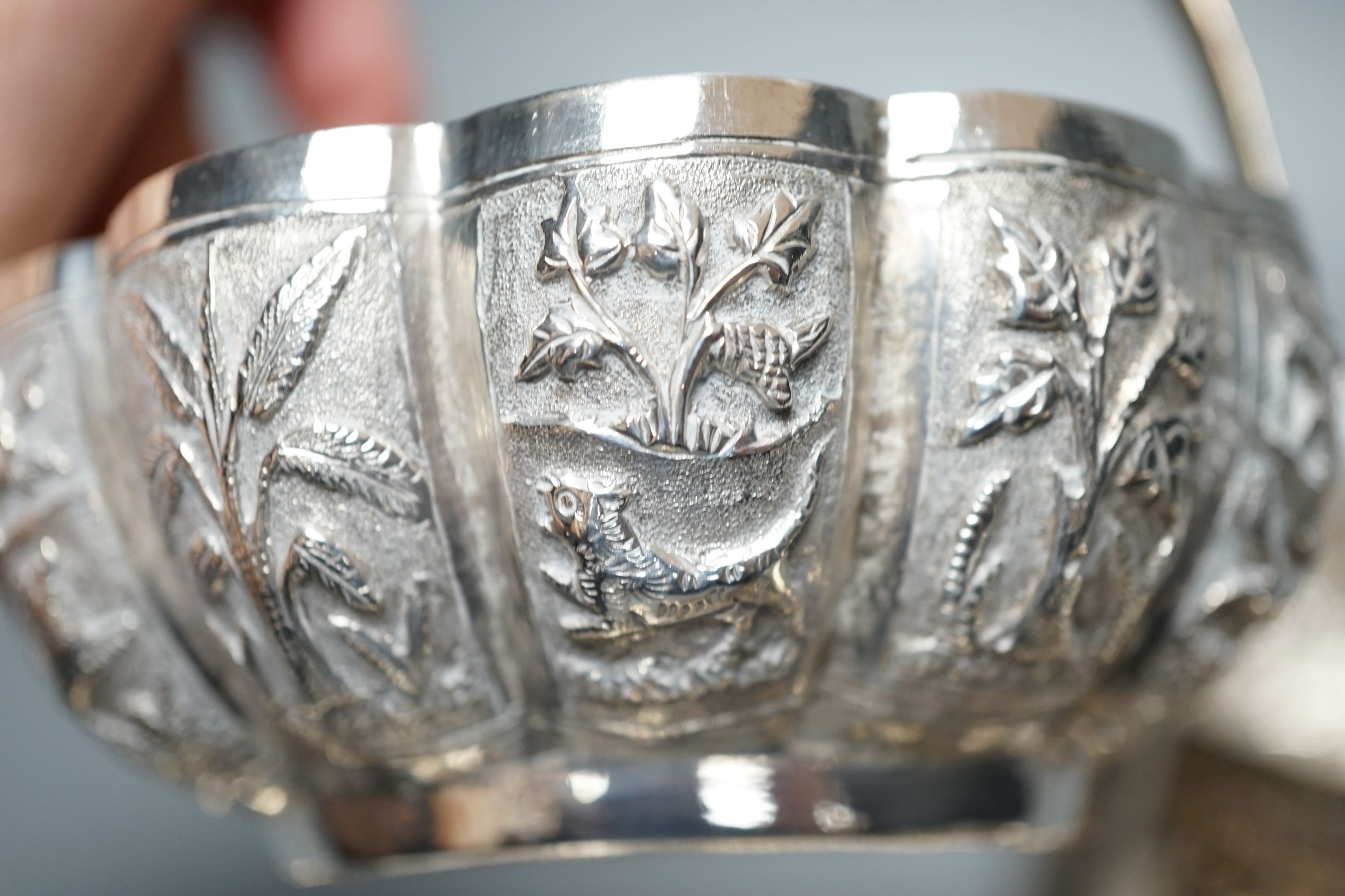 Four small Rangoon white metal bowls together with a simile basket and six small white metal bowls with heraldic motifs, gross 24.5oz.